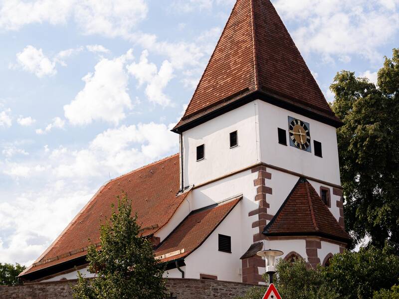 Eine Kirche umringt von ein paar Bäumen.