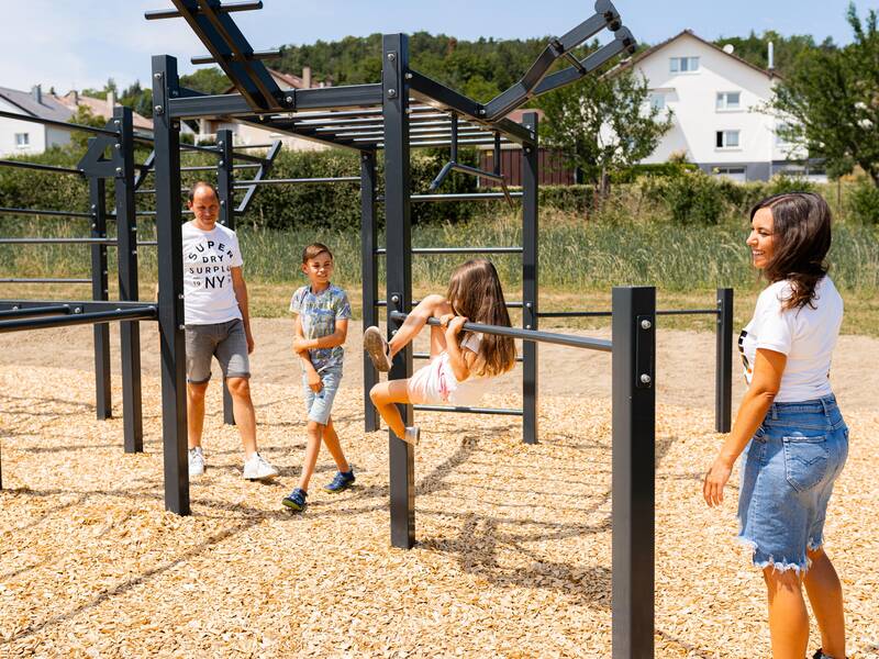 Eine Familie klettert an einer Sportanlage.