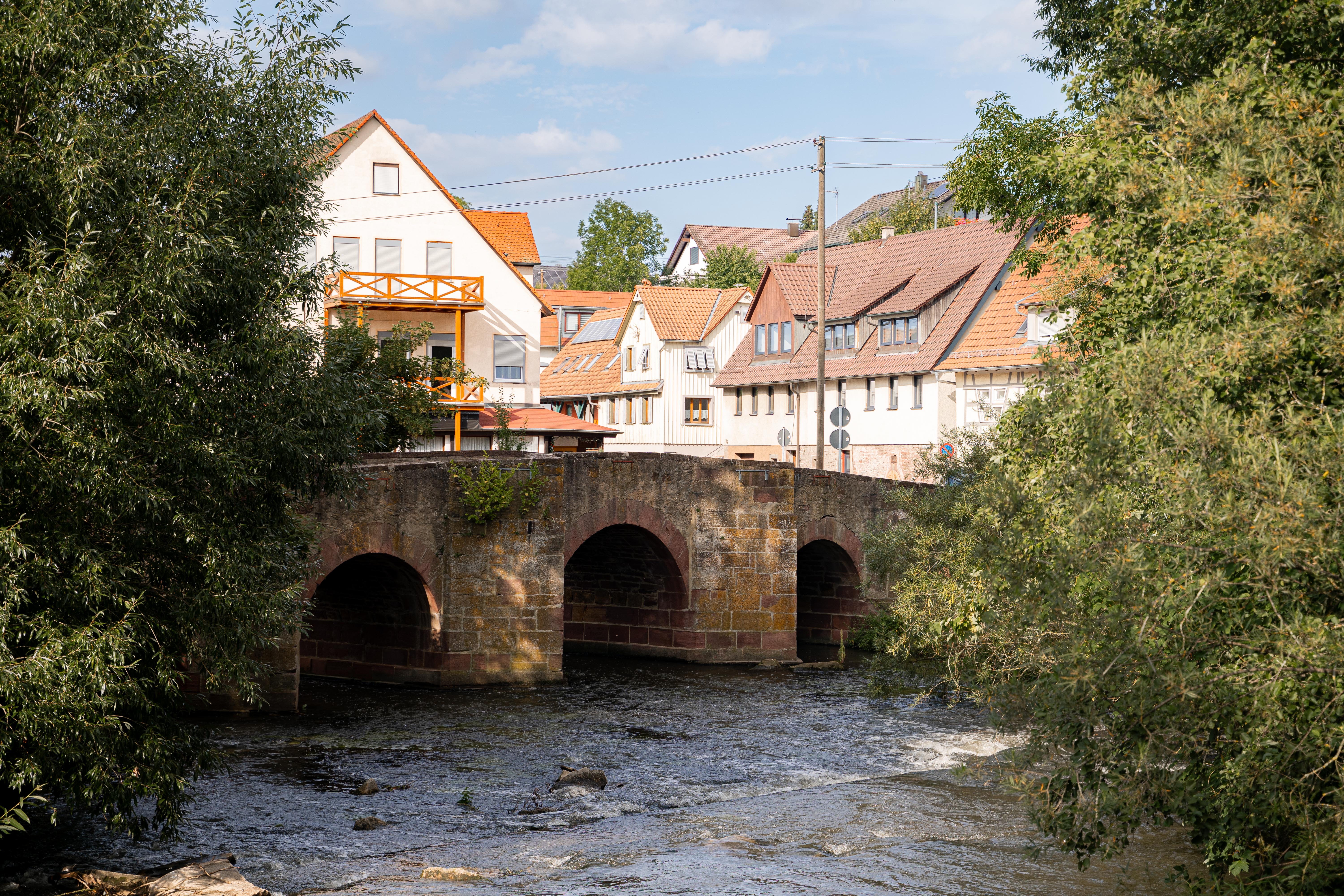 Unter einer Brücke fließt ein Fluss.